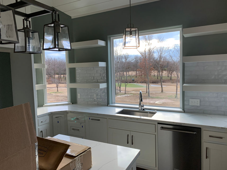 Black pendant fixtures above a bright kitchen island